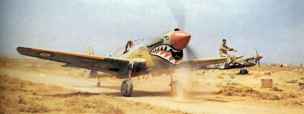 A P-40 Kittyhawk of No. 112 Squadron taxiing through the North African scrub.