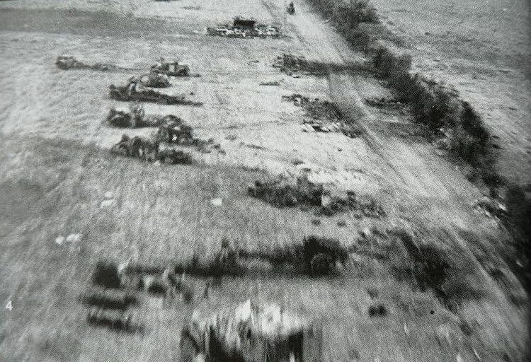 A Hawker Typhoon fighter bomber flying over a destroyed German column attempting to escape the Falaise pocket