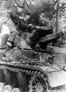 A Panzer MK IV crew from the 21st Panzer Division enjoying some cigars together in Normandy.